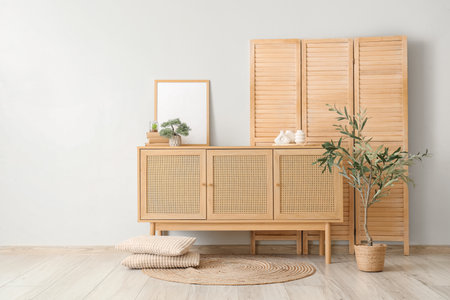 Folding screen and home decor on commode near white wallの写真素材