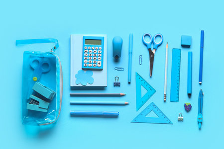 Pencil case with different stationery on blue background. Top viewの写真素材