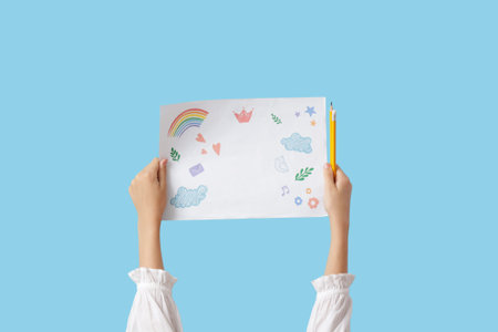 Child with drawing and pencils on blue background