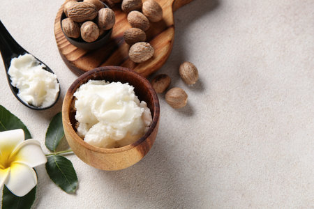 Bowl and spoon of shea butter with nuts on white backgroundの写真素材
