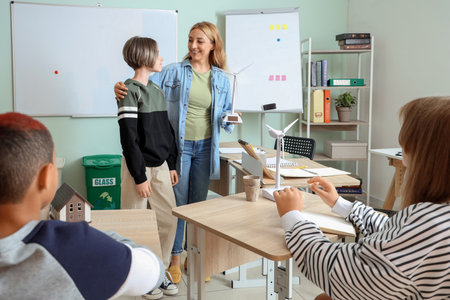 Female teacher with wind turbine model and teenage boy during Ecology lesson in classroomの写真素材
