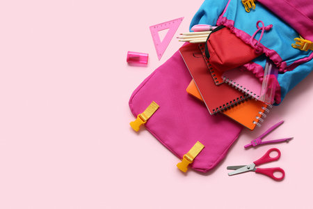 Modern school backpack with different stationery supplies on pink backgroundの写真素材