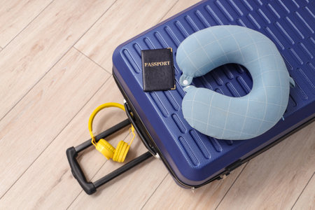 Packed suitcase on floor with neck pillow, headphones and passport. Top viewの写真素材