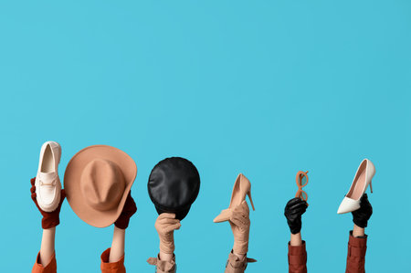 Female hands in gloves with sunglasses, different hat and shoes on blue backgroundの写真素材