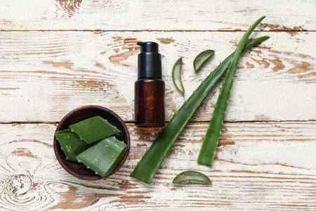 Wooden bowl and bottle of essential aloe vera oil on wooden backgroundの写真素材