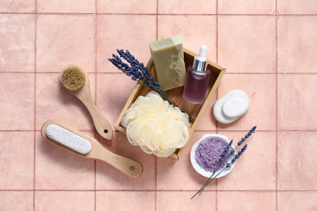 Beautiful composition with bath supplies, sea salt and bottle of lavender oil on pink tile backgroundの写真素材