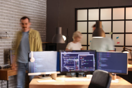 Team of programmers working in office at night, blurred viewの写真素材