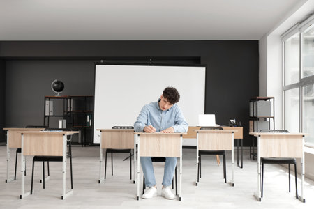 Male student passing exam in classroomの写真素材