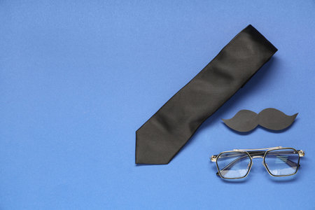 Paper mustache, glasses and tie on blue background. Father's Day celebration. Top viewの写真素材