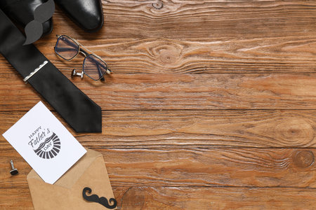 Man's accessories and envelope with text HAPPY FATHER'S DAY on wooden background. Top viewの写真素材