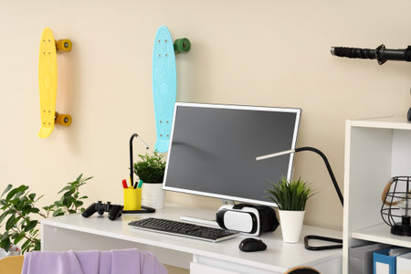 Teenager's workplace with modern gadgets and plants in room