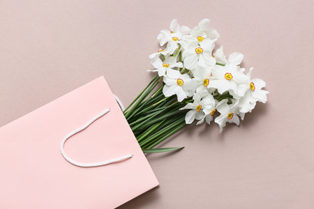 Shopping bag with beautiful daffodil flowers on beige backgroundの写真素材