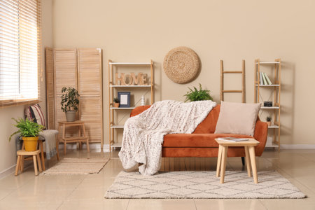 Cozy sofa with plaid and coffee table with magazine in interior of living room