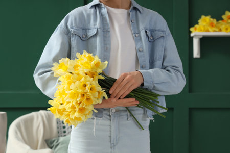 Woman with beautiful daffodils at home, closeupの写真素材