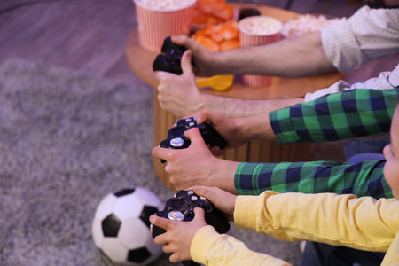 Little children with their father playing video game at home in evening, closeupの写真素材