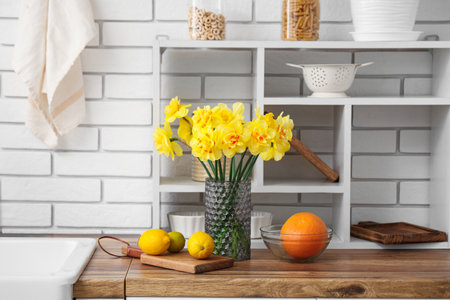 Beautiful bouquet of daffodils in interior of modern kitchenの写真素材