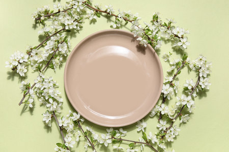 Beautiful table setting with blossoming branches on green backgroundの写真素材