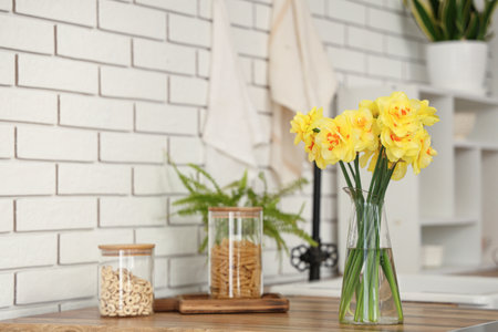 Beautiful bouquet of narcissus in interior of modern kitchenの写真素材