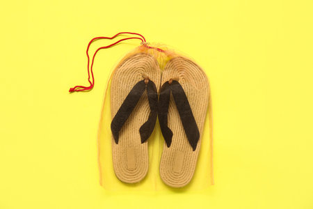 Bag with flip flops on yellow backgroundの写真素材