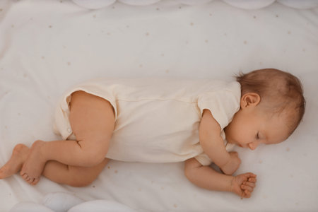 Cute little baby sleeping in crib, top view