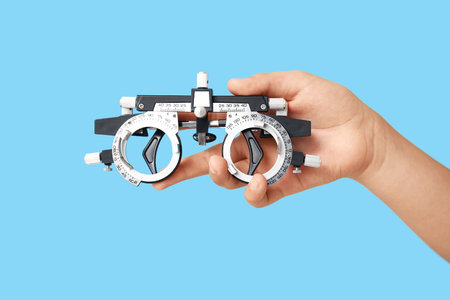 Teenage girl with trial frame on blue background. Children's Eye Health and Safety Awareness Month