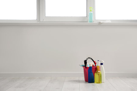 Bottles of detergent and bucket near window at homeの写真素材