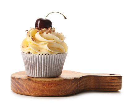 Wooden board with sweet cherry cupcake on white backgroundの写真素材