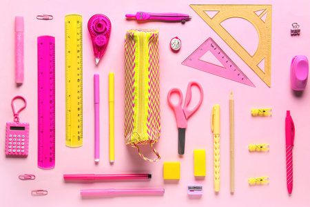 Pencil case with different stationery on pink background. Top view