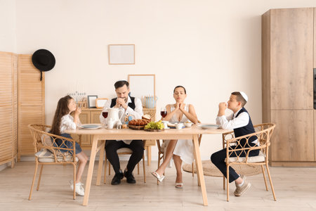 Jewish family praying before dinner at homeの写真素材