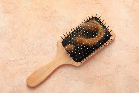 Brush and question mark made of hair strand on beige background. Hair loss problem