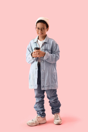 Little African-American boy in adult clothes with coffee cup on pink backgroundの写真素材