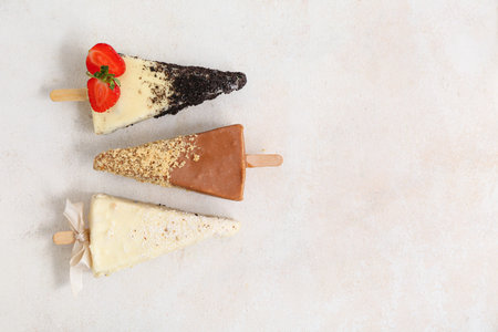 Tasty cheesecake pops on light background with space for text