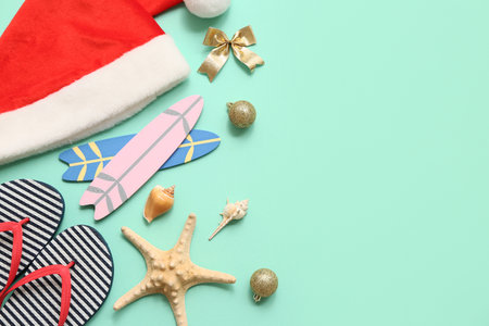 Santa's hat with Christmas balls and beach accessories on turquoise background. Top viewの写真素材