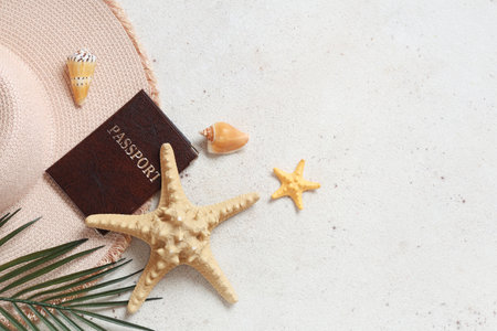 Beautiful composition with starfishes, hat and passport on light grunge backgroundの写真素材