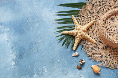 Beautiful composition with hat, seashells and starfish on blue grunge backgroundの写真素材