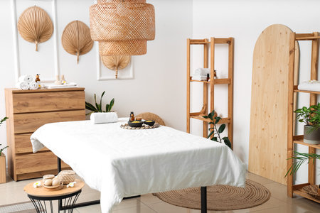 Interior of light spa salon with massage couch, fans and shelf unitsの写真素材