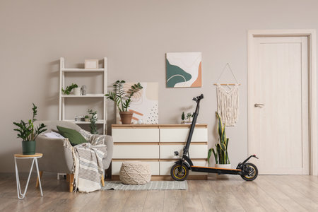Interior of light living room with electric scooter, drawers and armchairの写真素材