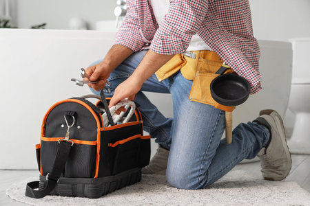 Male plumber with bag of tools in bathroom, closeupの写真素材