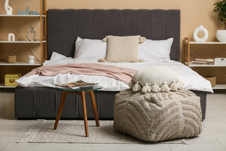 Interior of stylish bedroom with shelf units, pouf and tableの写真素材