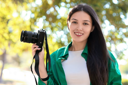 Female Asian photographer with camera outdoors, closeupの写真素材