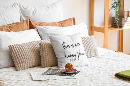 Big comfortable bed with muffin and many pillows in interior of bedroomの写真素材
