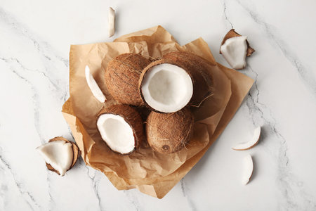 Baking paper with fresh coconuts on white background