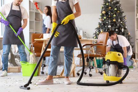 Female janitor cleaning floor in office after New Year partyの写真素材