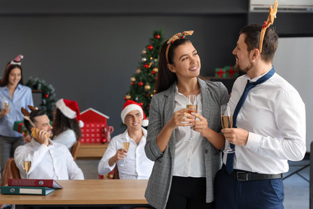 Business people in reindeer horns with champagne celebrating New Year at partyの写真素材