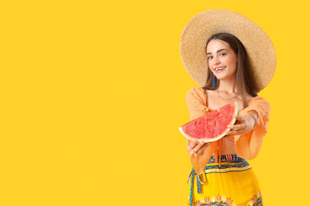 Fashionable young woman in hat with watermelon on yellow background