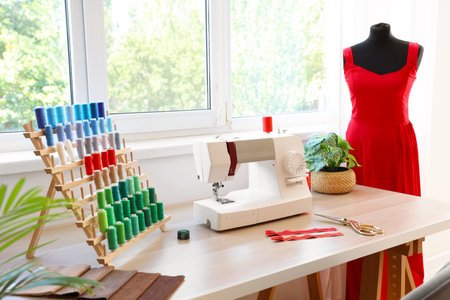 Tailor's workplace with sewing machine and thread spools in atelierの写真素材
