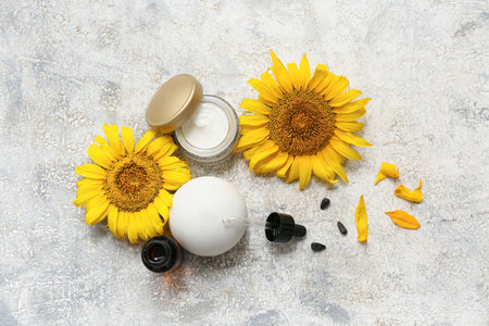 Composition with cosmetic products and beautiful sunflowers on grunge backgroundの写真素材