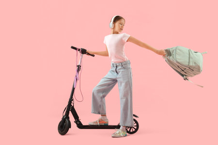 Hurrying schoolgirl with backpack riding electric scooter on pink background