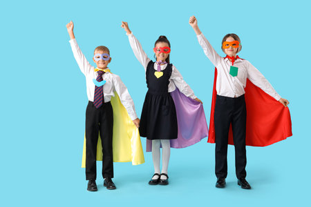 Happy pupils dressed as superheroes on blue backgroundの写真素材