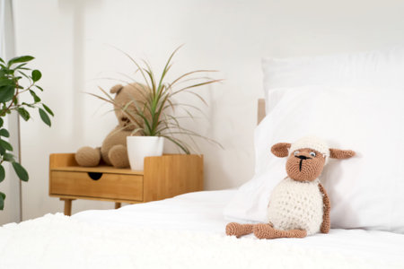 Plush toy on cozy bed in interior of children's bedroom, closeup